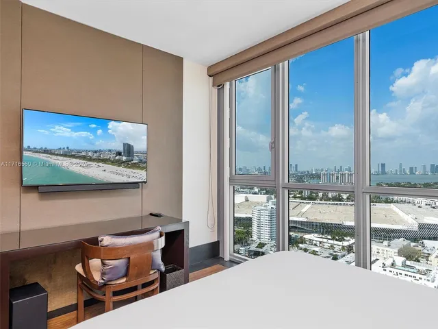 a bedroom with furniture and large window