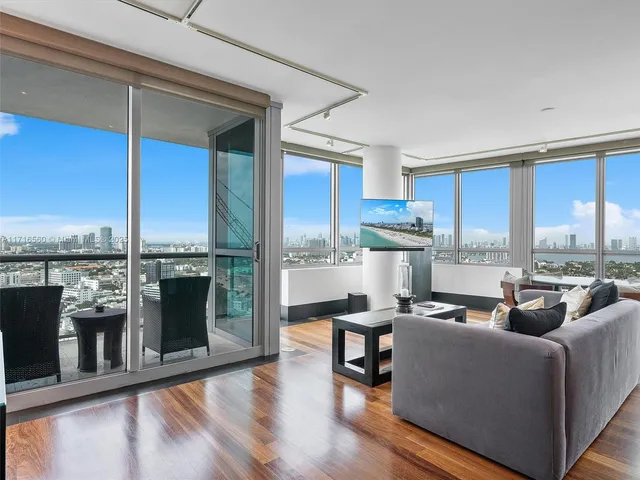 a living room with furniture stove and kitchen view