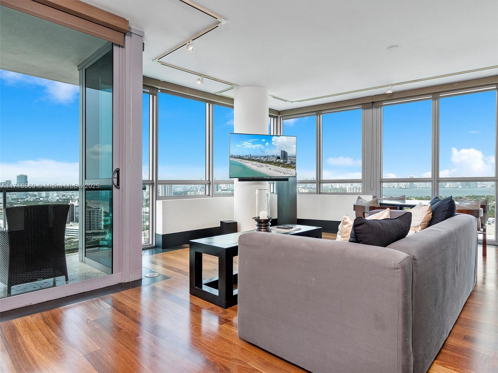 101 20th Street, Unit 3302 Miami Beach, FL 33139 - Photo 6 of 48 a living room with furniture a fireplace and a floor to ceiling window