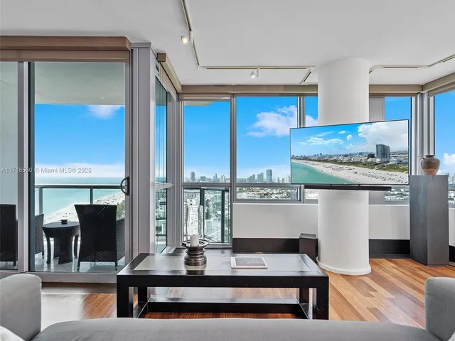 a living room with stainless steel appliances kitchen island granite countertop furniture and a large window