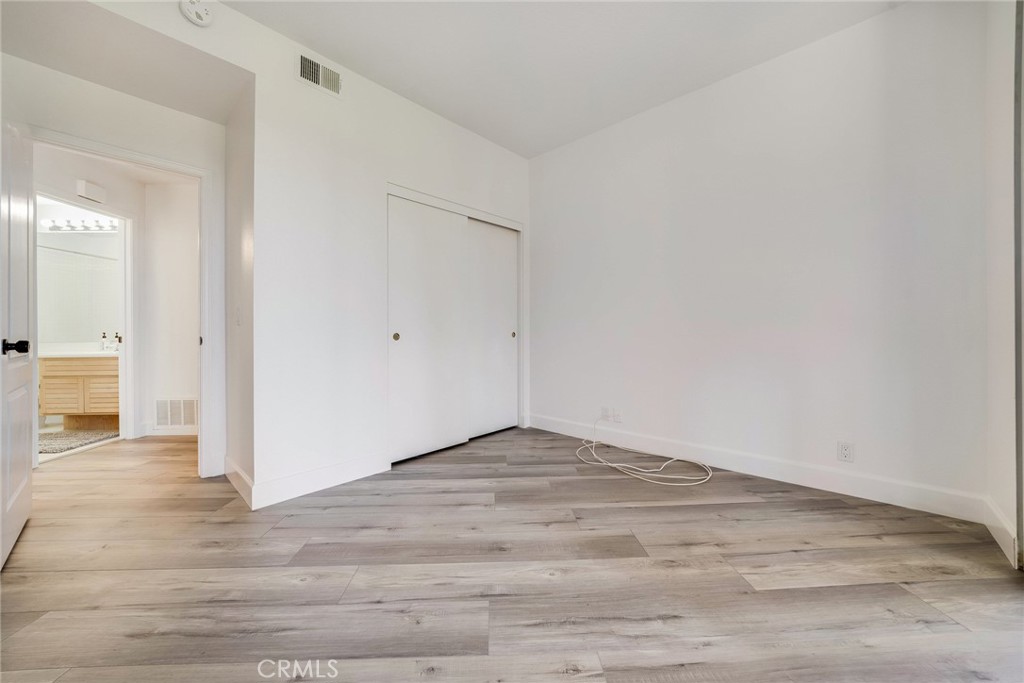 43 Auburn Aisle Irvine, CA 92612 - Photo 16 of 19 Secondary bedroom with high ceilings, wide planked vinyl flooring and standard sized closet space.