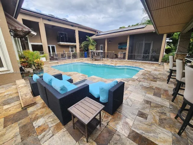 a view of patio with table and chairs under an umbrella
