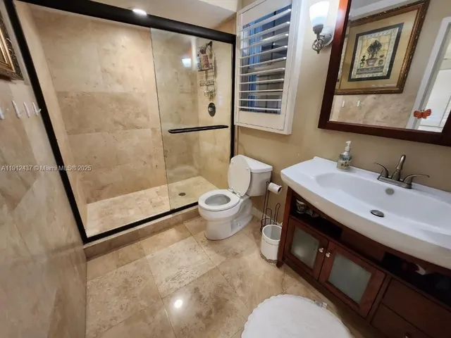 a bathroom with a sink mirror vanity and toilet