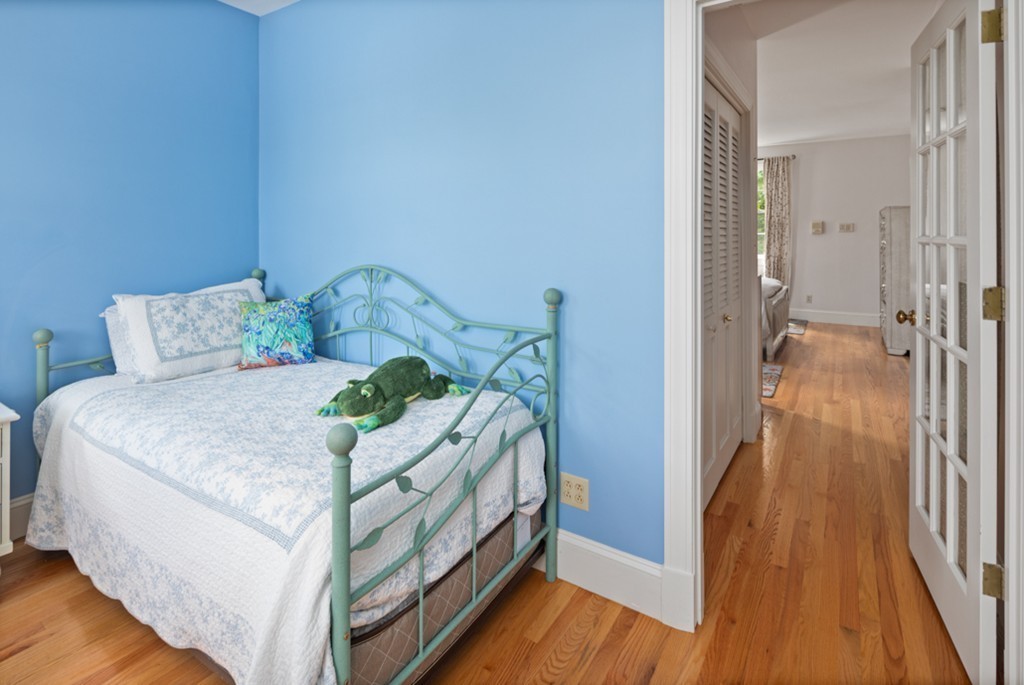 1193 Main Street, Unit D1 Hingham, MA 02043 - Photo 17 of 34 a bedroom with a bed and a wooden floor