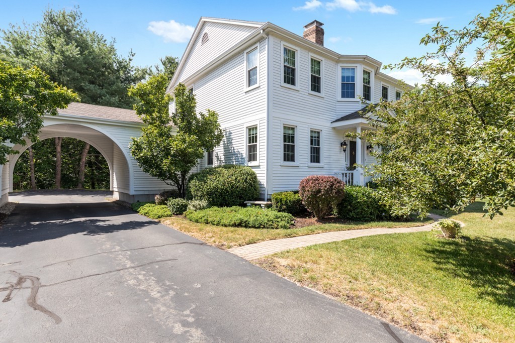 1193 Main Street, Unit D1 Hingham, MA 02043 - Photo 31 of 34 a front view of a house with a yard and garage