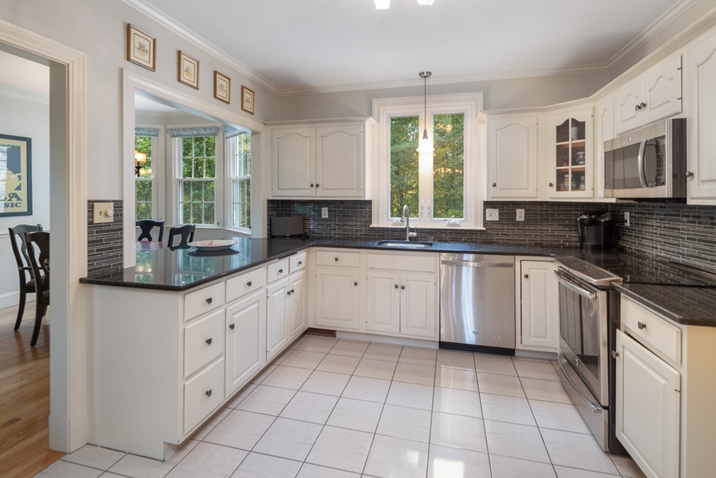 1193 Main Street, Unit D1 Hingham, MA 02043 - Photo 9 of 34 a kitchen with granite countertop white cabinets white appliances with a sink and dishwasher