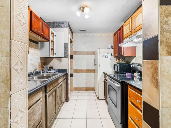 a kitchen with stainless steel appliances granite countertop a stove a sink and a refrigerator