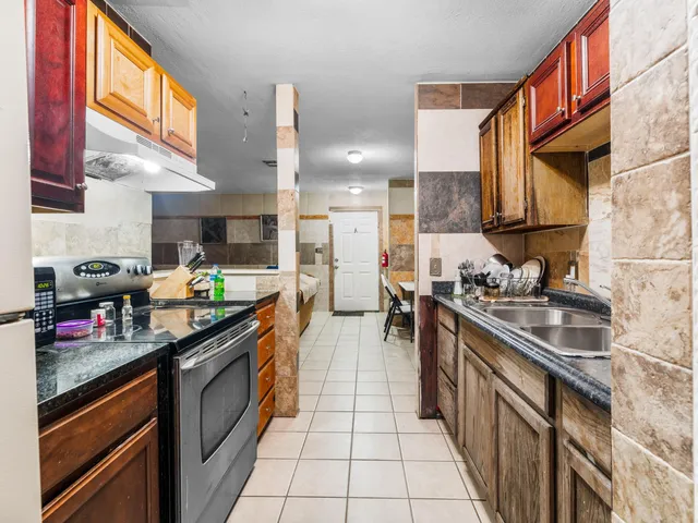 a kitchen with stainless steel appliances granite countertop a sink stove and cabinets