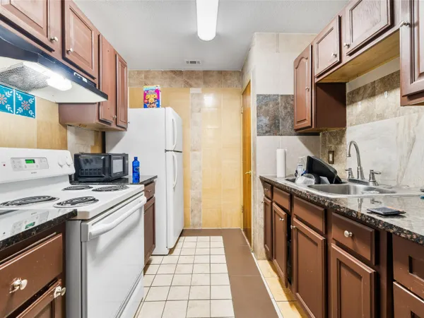 a kitchen with a white stove top oven sink and cabinets