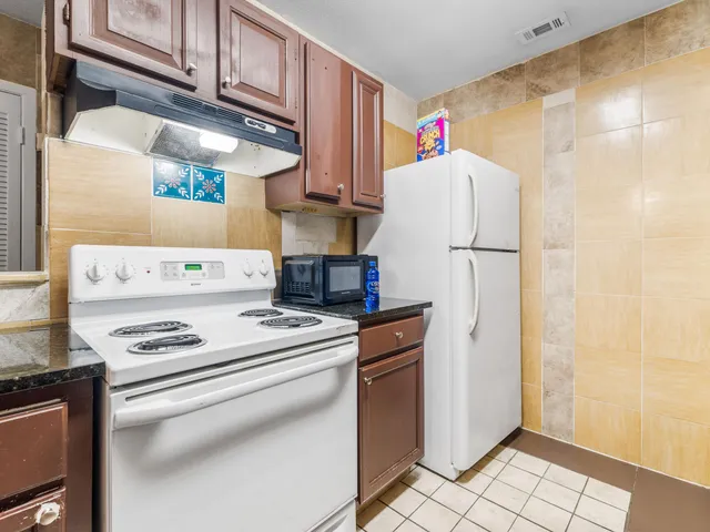 a white refrigerator freezer and a stove sitting inside of a kitchen