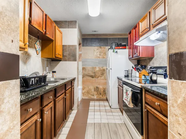 a kitchen with stainless steel appliances granite countertop a stove and a refrigerator