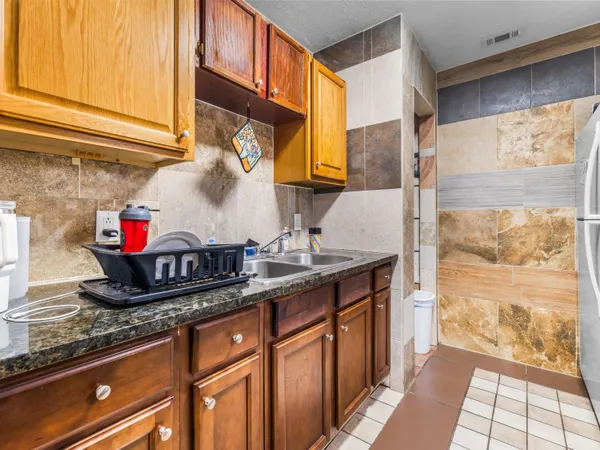 a kitchen with granite countertop a sink and a white cabinets