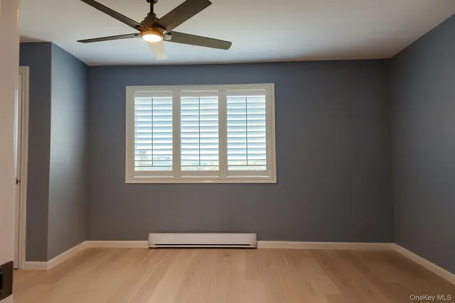 an empty room with a window and a fan