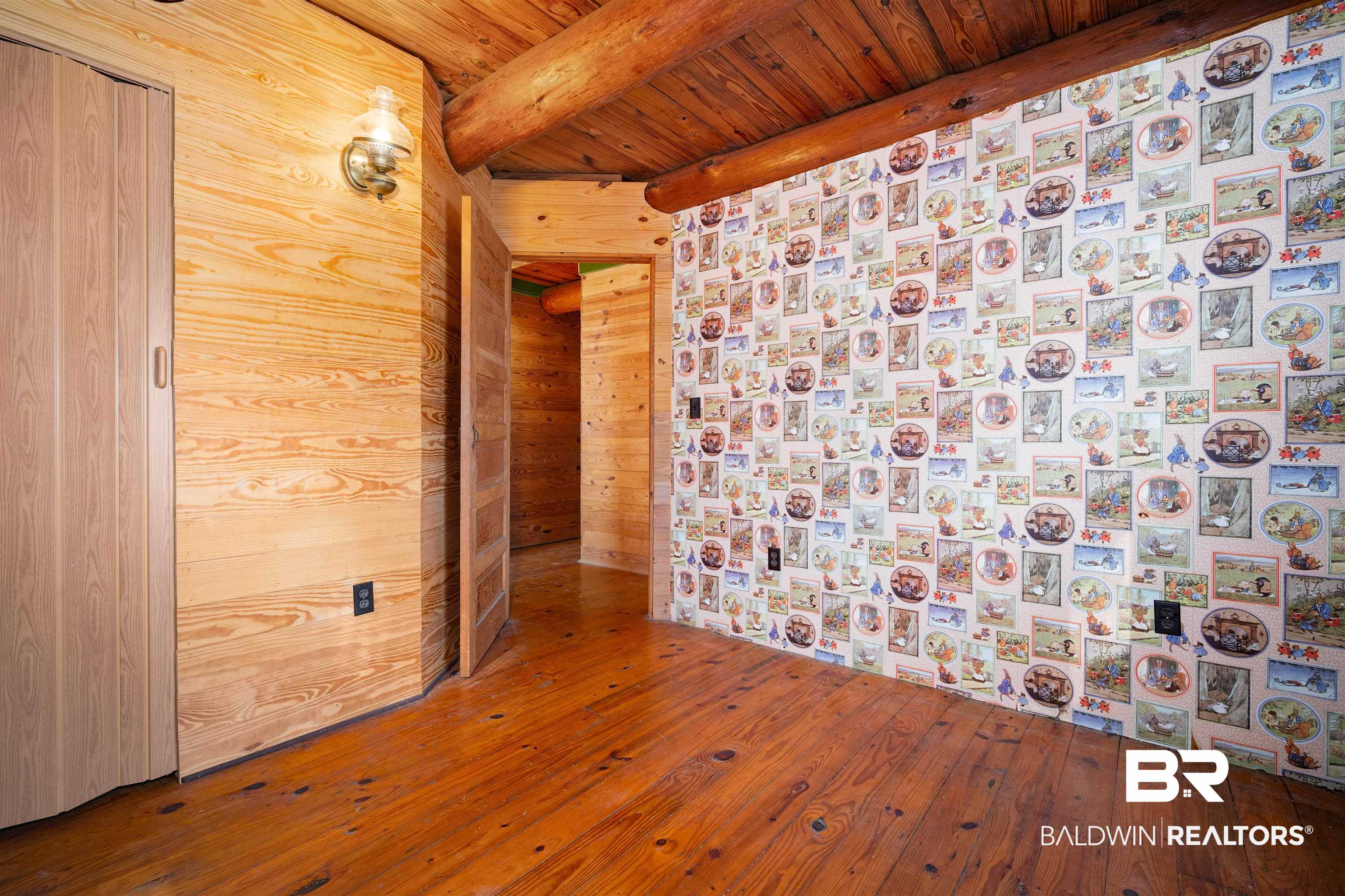 11236 Wren Avenue Fairhope, AL 36532 - Photo 20 of 35 Empty room with a wooden ceiling with exposed beams, wooden walls, and hardwood / wood-style flooring