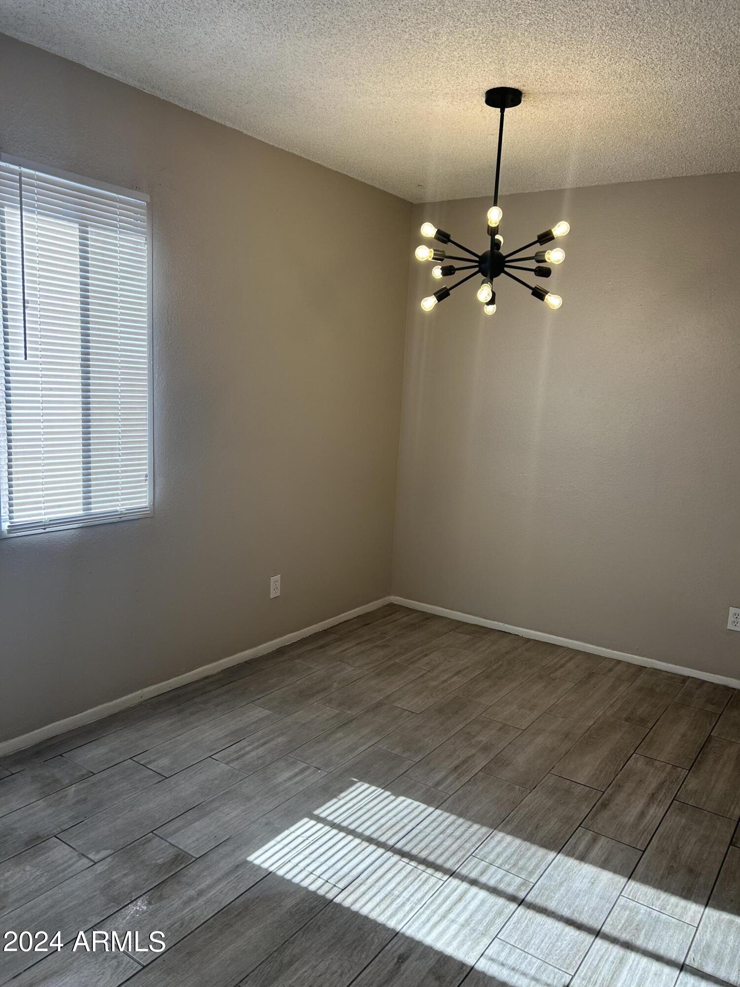 8233 North 34th Drive Phoenix, AZ 85051 - Photo 3 of 11 an empty room with wooden floor fan and window