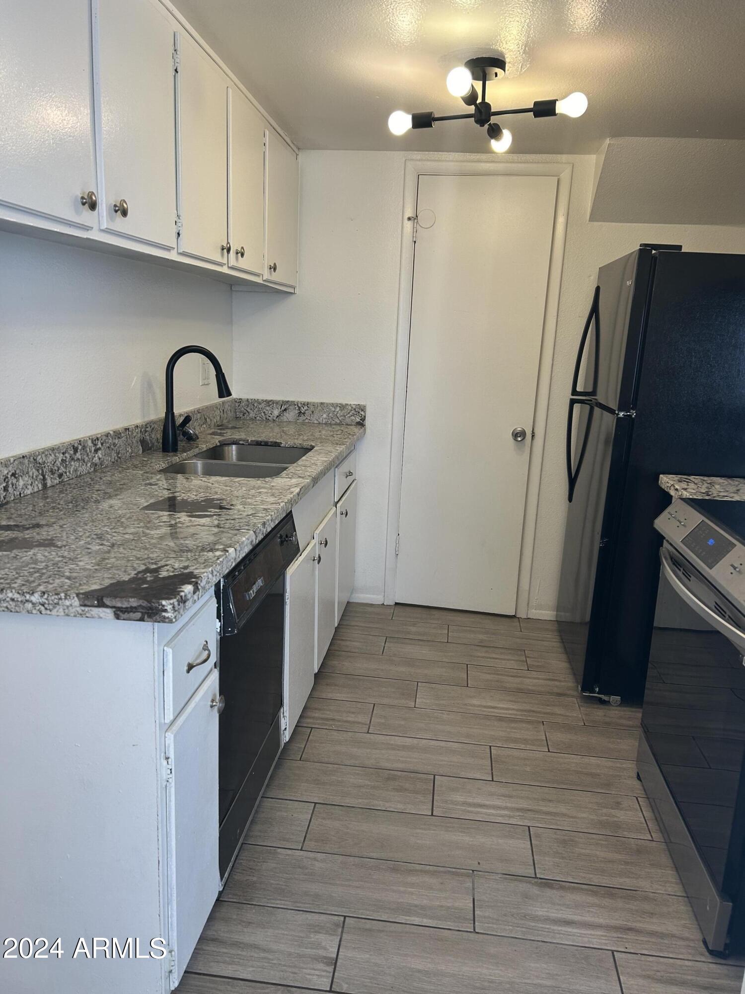 8233 North 34th Drive Phoenix, AZ 85051 - Photo 4 of 11 a kitchen with stainless steel appliances granite countertop a refrigerator and a sink