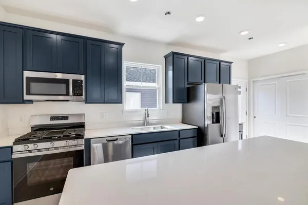 a kitchen with stainless steel appliances a refrigerator stove and microwave