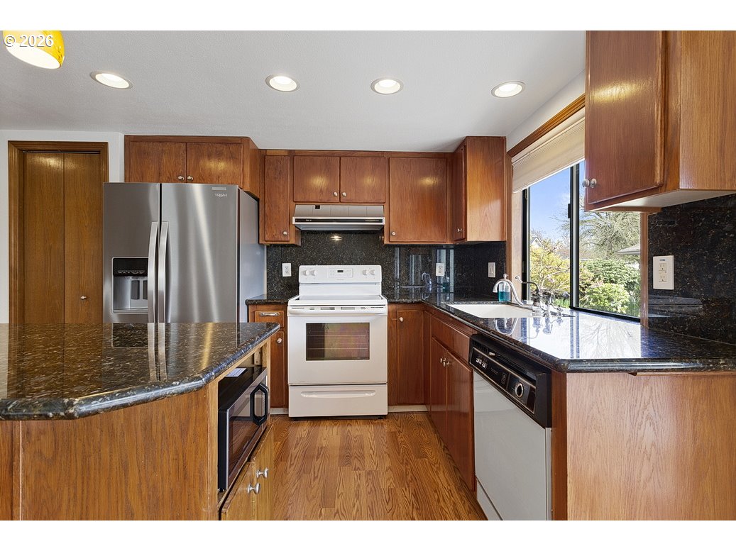 15638 Northeast Russell Place Portland, OR 97230 - Photo 15 of 46 a kitchen with kitchen island a counter top space a sink stainless steel appliances and cabinets