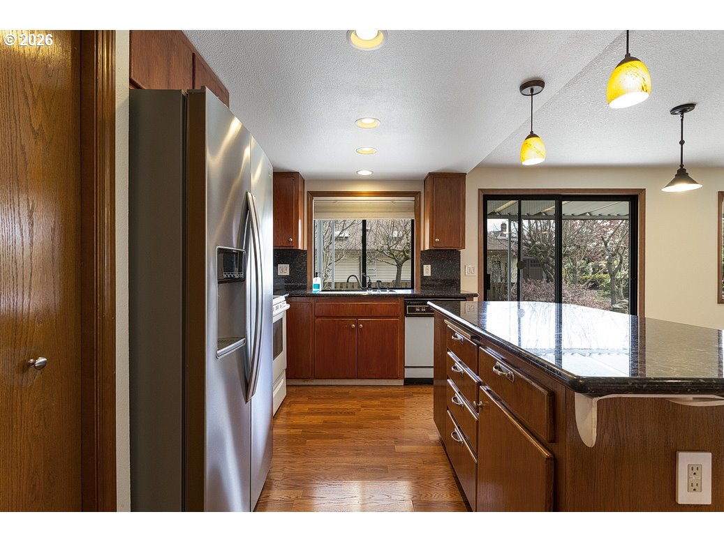 15638 Northeast Russell Place Portland, OR 97230 - Photo 18 of 46 a kitchen with a refrigerator and a wooden floor