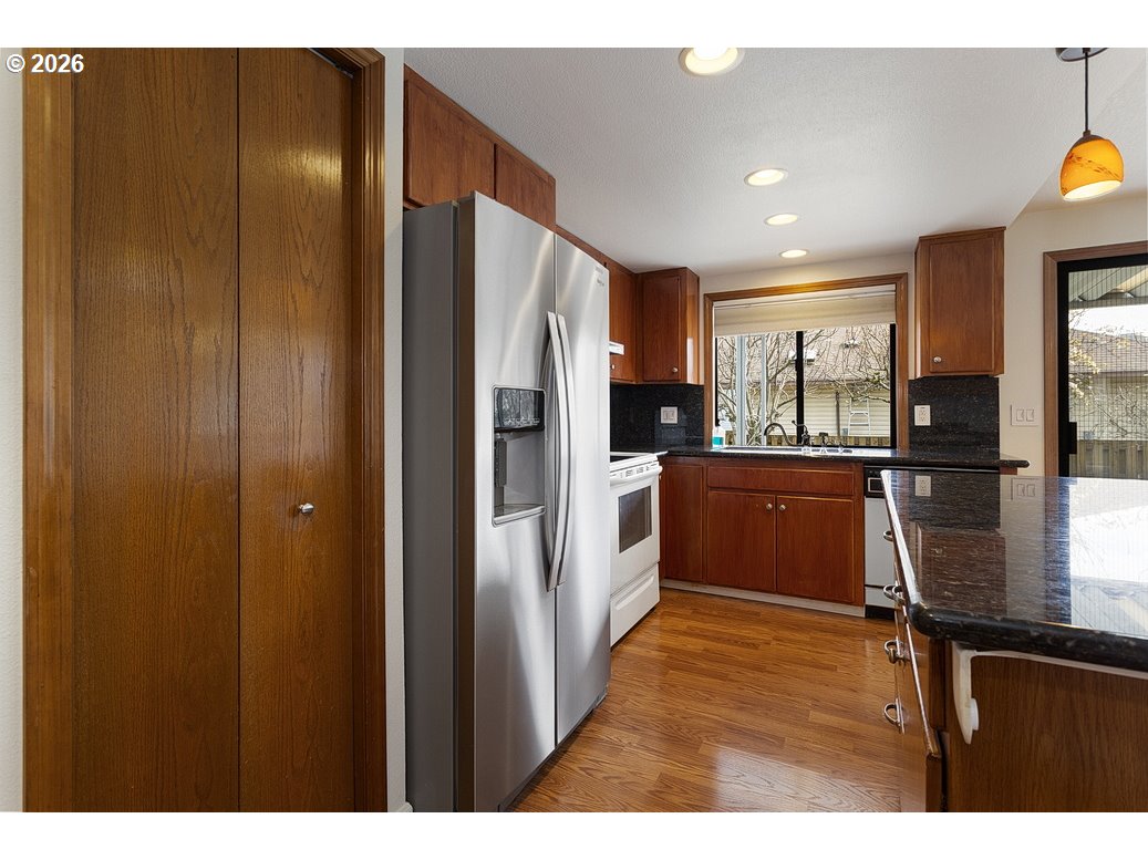 15638 Northeast Russell Place Portland, OR 97230 - Photo 19 of 46 a kitchen with stainless steel appliances kitchen island granite countertop a refrigerator and a sink