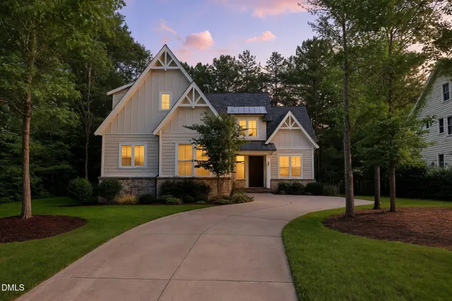 a front view of a house with a yard and trees