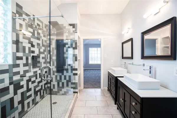 a bathroom with a double vanity sink a toilet a mirror and shower