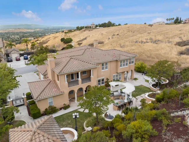 a view of a patio with couches and table and chairs with wooden fence
