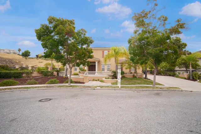 a view of a house with backyard fountain and sitting area