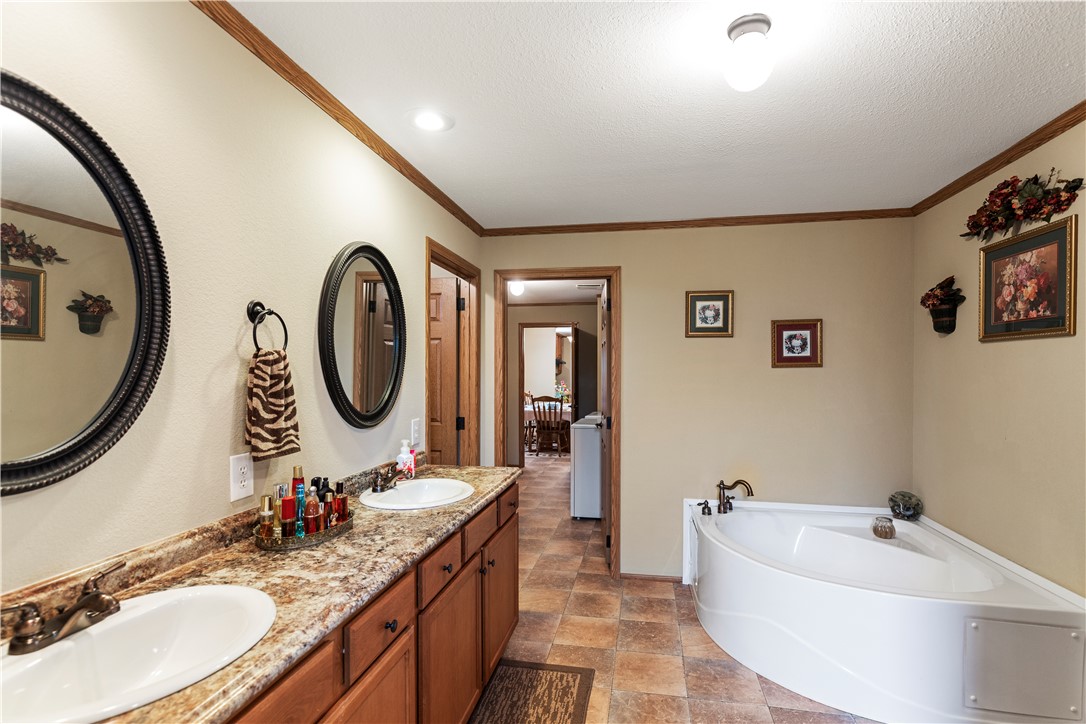 265 A State Rd S-37-141 Westminster, SC 29693 - Photo 21 of 33 Dual vanity sinks complement a spacious soaking tub in this inviting primary bathroom.
