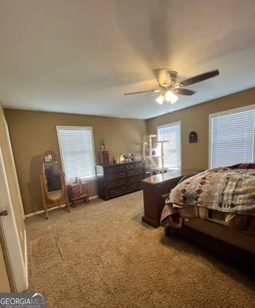 a spacious bedroom with a bed and a chandelier