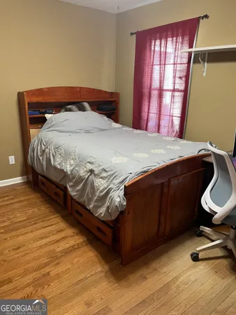 a bedroom with a bed chair and dresser