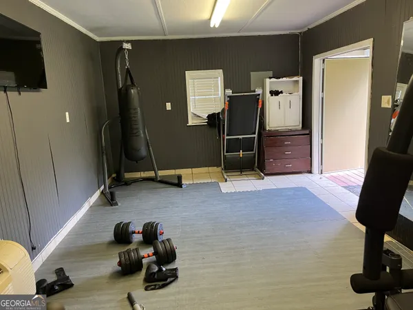 a room with gym equipment and a flat screen tv