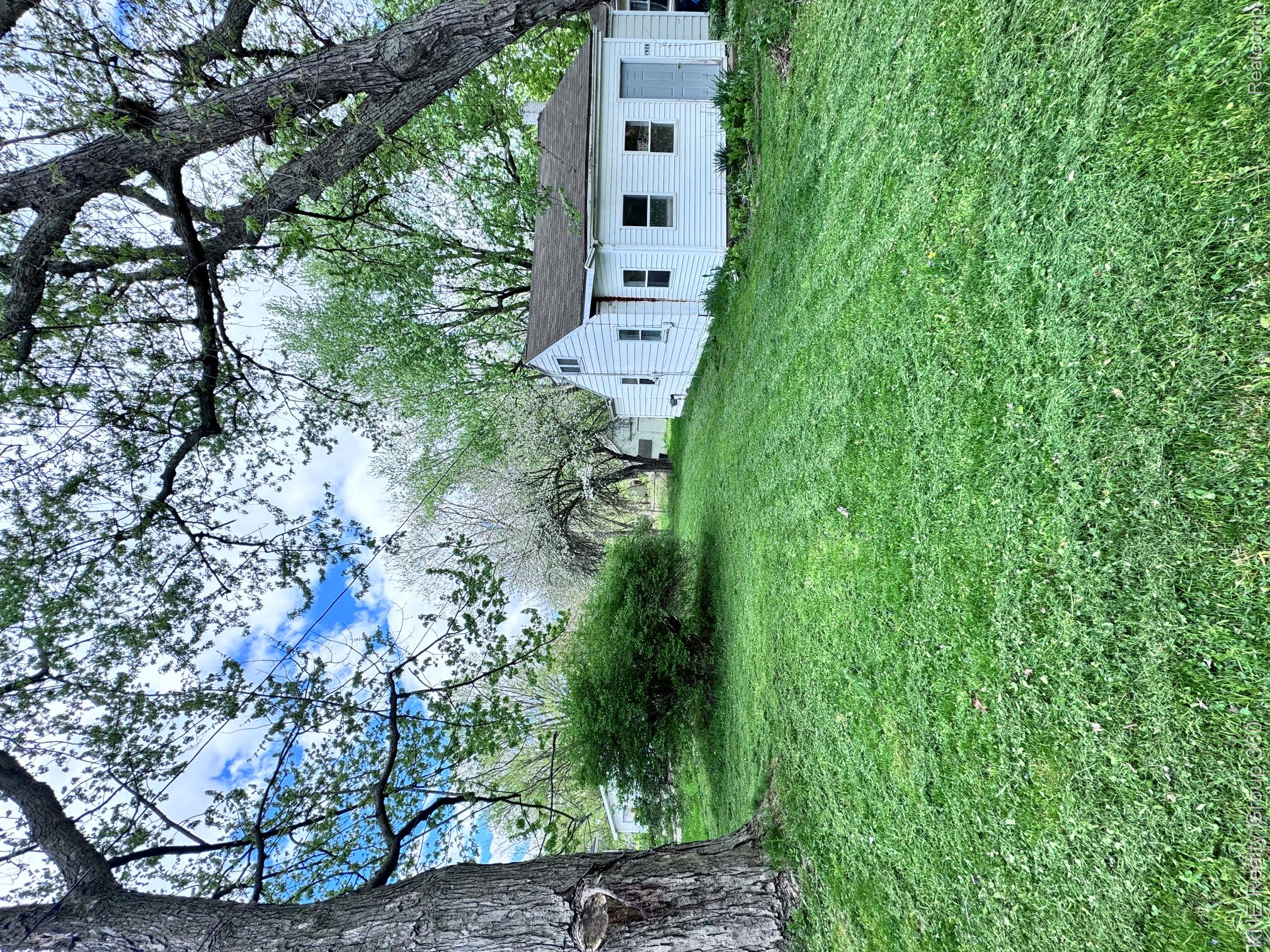 4928 Hughes Road Lansing, MI 48910 - Photo 28 of 35 Expansive green lawn with mature trees and a white-sided structure