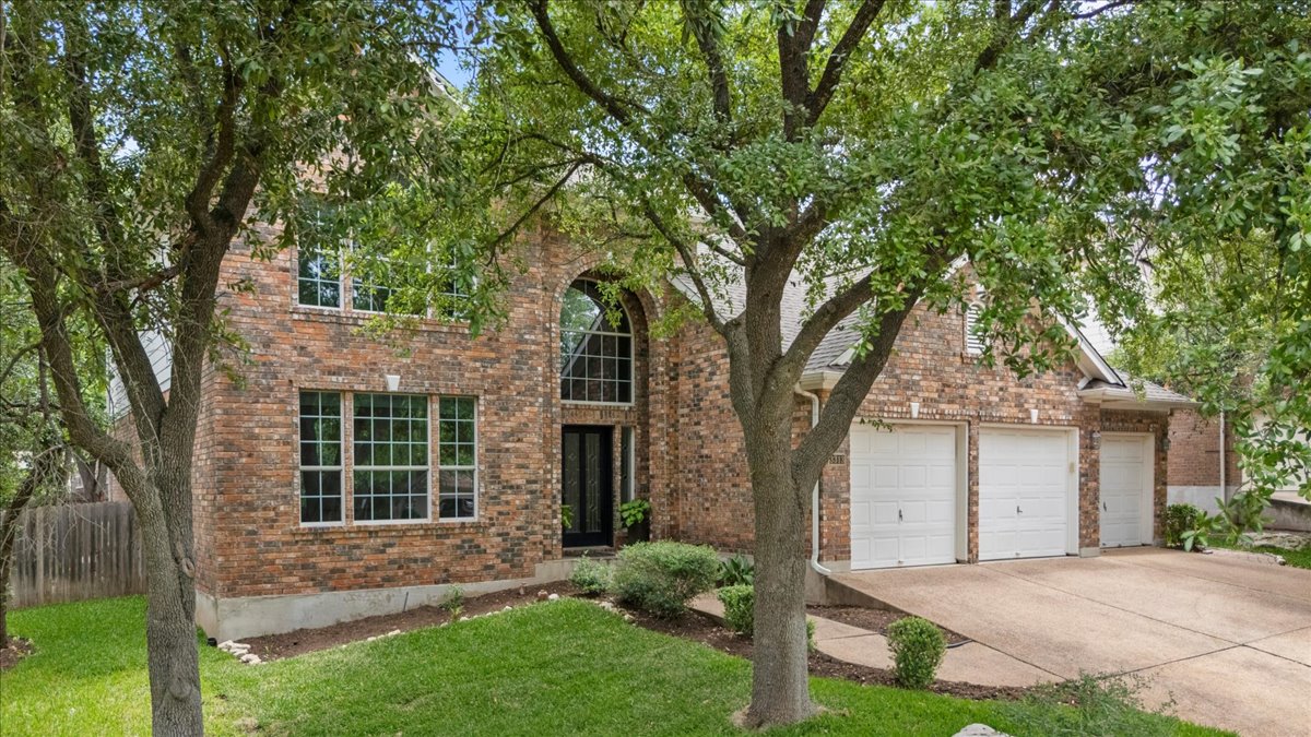 a front view of a house with a garden and yard