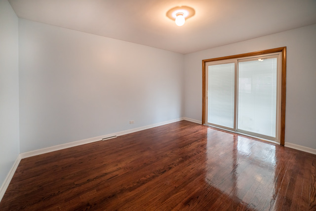 7609 Traube Street North Riverside, IL 60546 - Photo 11 of 25 an empty room with wooden floor and windows