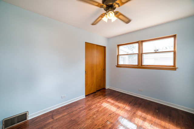 7609 Traube Street North Riverside, IL 60546 - Photo 14 of 25 a view of an empty room with wooden floor and a window
