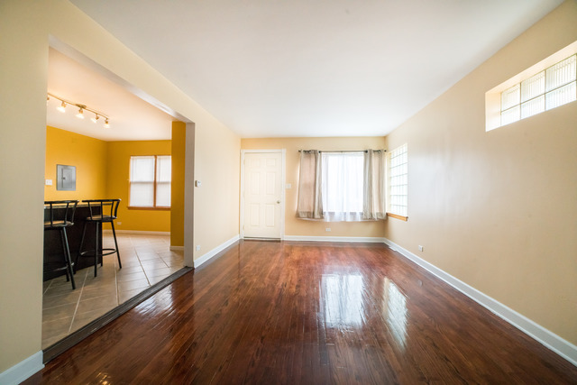 7609 Traube Street North Riverside, IL 60546 - Photo 3 of 25 a view of a big room with wooden floor windows and chandelier