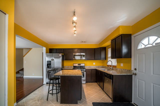 7609 Traube Street North Riverside, IL 60546 - Photo 4 of 25 a kitchen with granite countertop a sink and a refrigerator