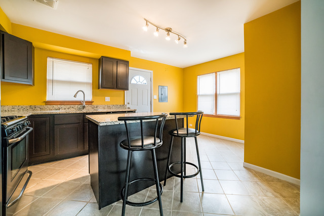 7609 Traube Street North Riverside, IL 60546 - Photo 6 of 25 a kitchen with stainless steel appliances granite countertop a sink counter space and a window