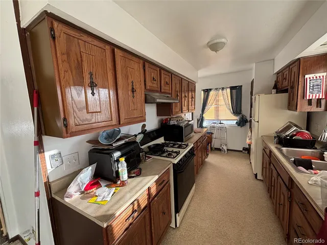 a kitchen with a stove a refrigerator and a sink