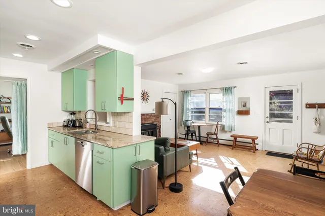 a kitchen with stainless steel appliances granite countertop a stove top oven a sink dishwasher a dining table and chairs with wooden floor