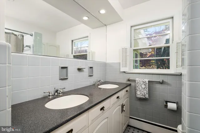 a bathroom with a granite countertop sink and a mirror