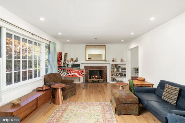 a living room with furniture a fireplace and a floor to ceiling window