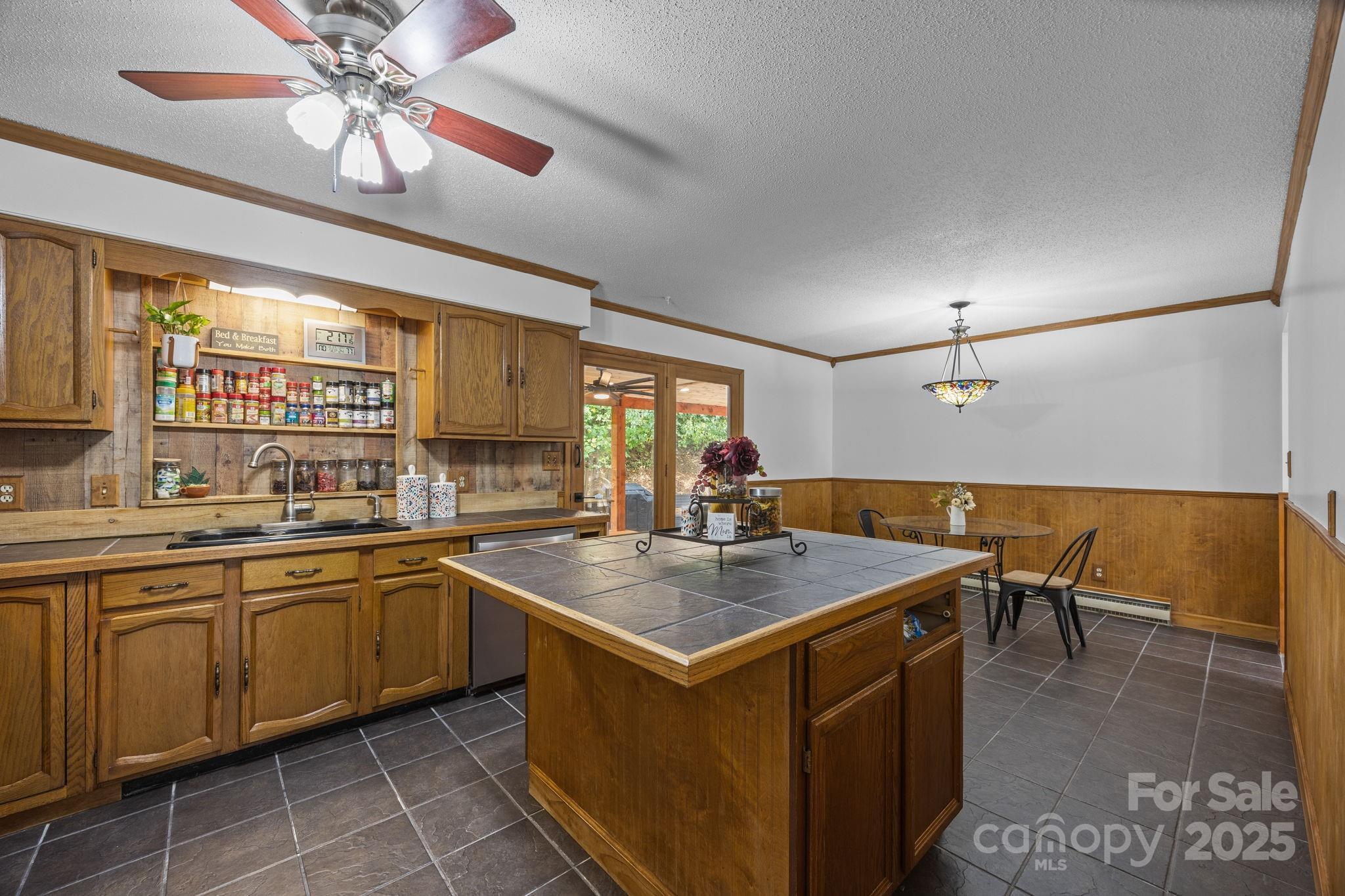 263 Morgan Branch Road Leicester, NC 28748 - Photo 21 of 31 a kitchen with a stove a sink a dining table and chairs with wooden floor
