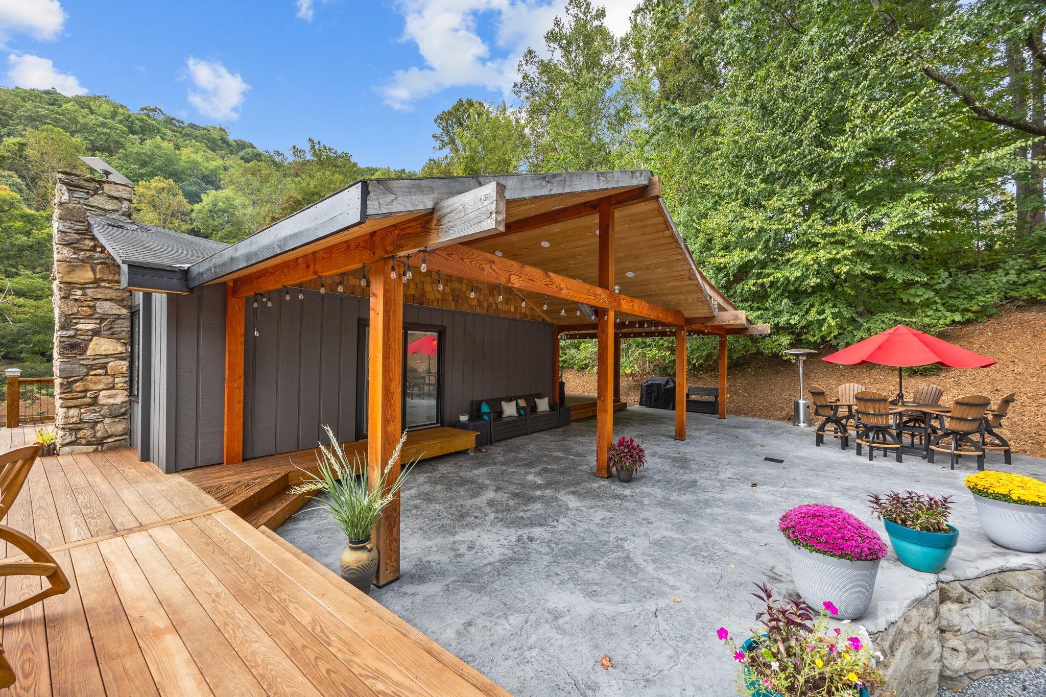 263 Morgan Branch Road Leicester, NC 28748 - Photo 4 of 31 a view of a patio with table and chairs under an umbrella