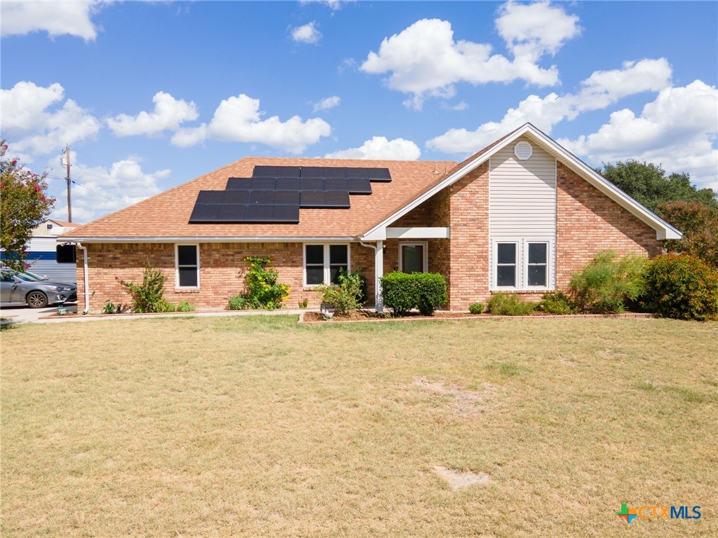 a front view of house with yard and trees around