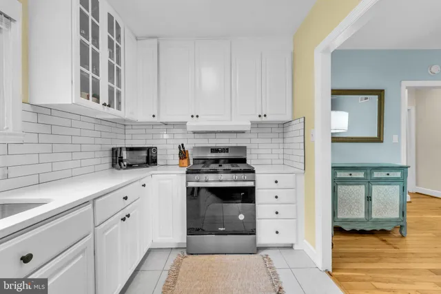 a kitchen with stainless steel appliances granite countertop white cabinets and a stove