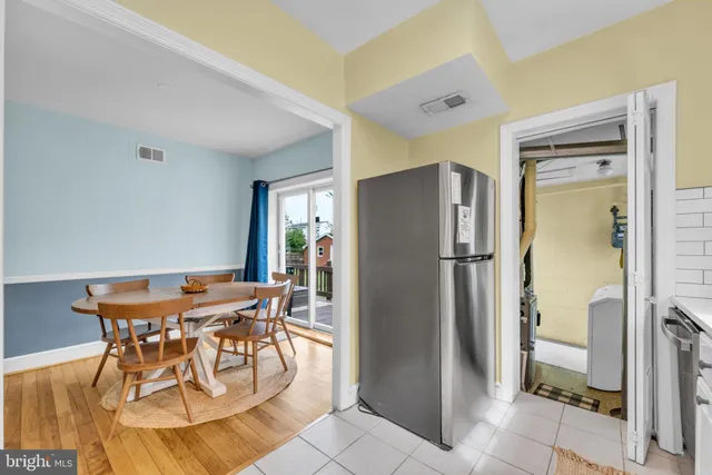 a view of a dining room with furniture and a refrigerator