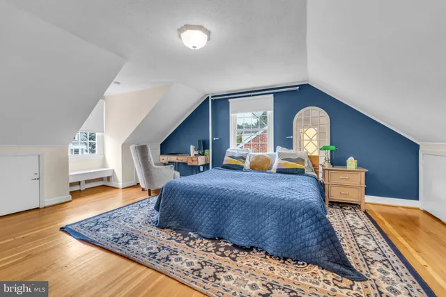a bed sitting in a spacious bedroom next to a window
