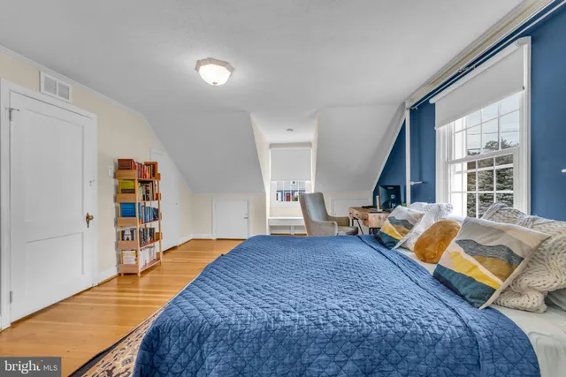 a bedroom with a bed and a large window